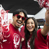 a male and female student cheering before a Temple football game. 