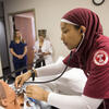 Student practicing with stethoscope on fake patient 